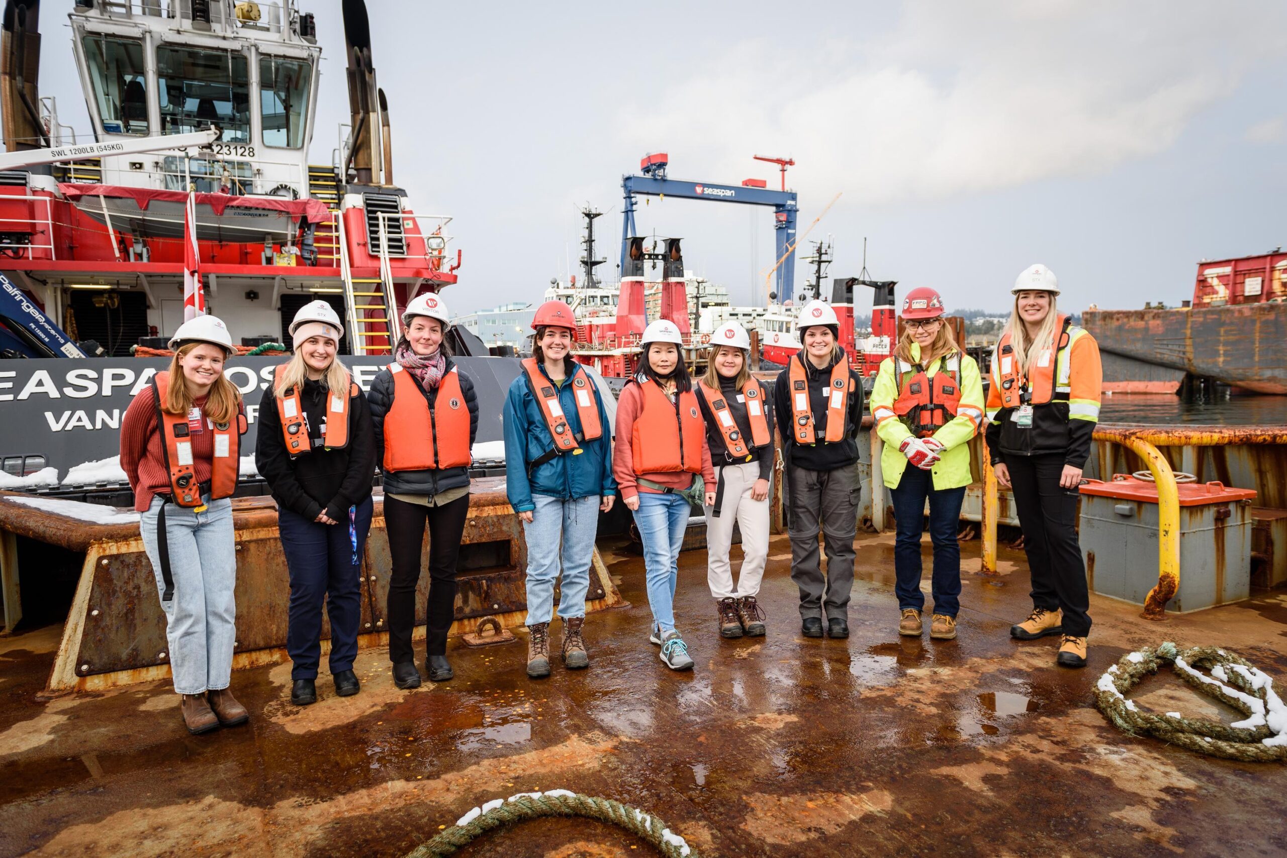 Group of women in front of tugboats